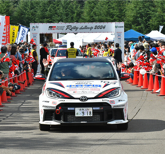 利府町で開催されたラリーチャレンジで、観客の中を走る参戦車両