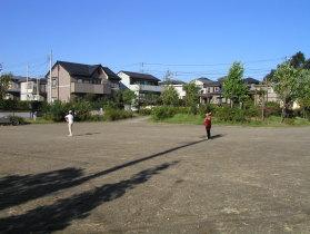 広場で二人の人がキャッチボールをしている姿が写っている写真