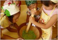 すり鉢で枝豆をすりつぶしている園児の写真